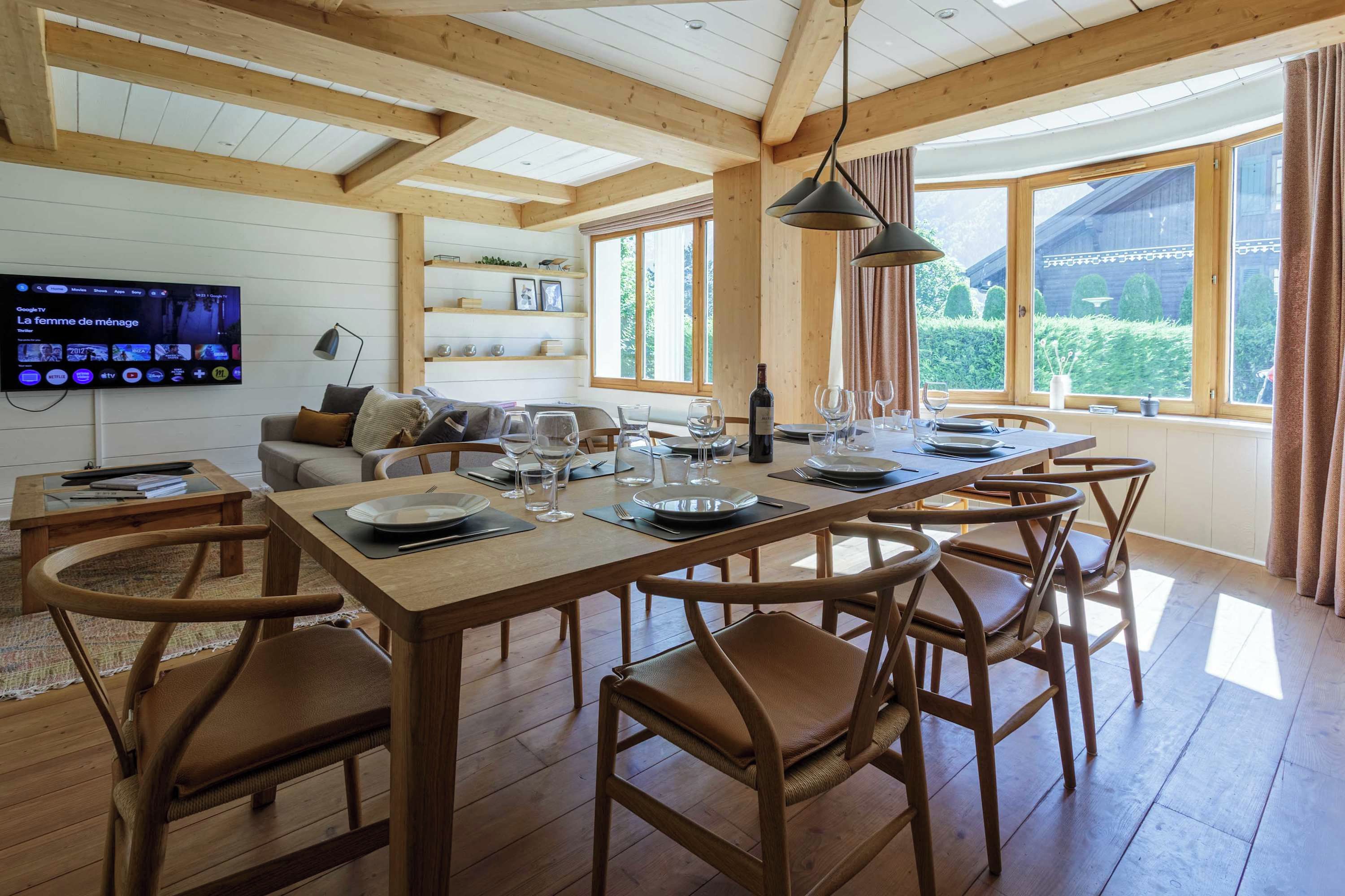 Comedor con mesa de madera dispuesta para seis personas, rodeado de sillas.