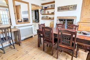 A dining area with wooden furniture, a white radiator, and a brick wall.