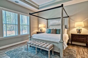 A four-poster bed with a bench, two bedside tables, and a large window with blinds. - Ocean View * 5BR Luxury Single Family House! (Ocean View)
