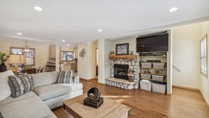 A living room with a fireplace, a sofa, a coffee table, and a TV stand.