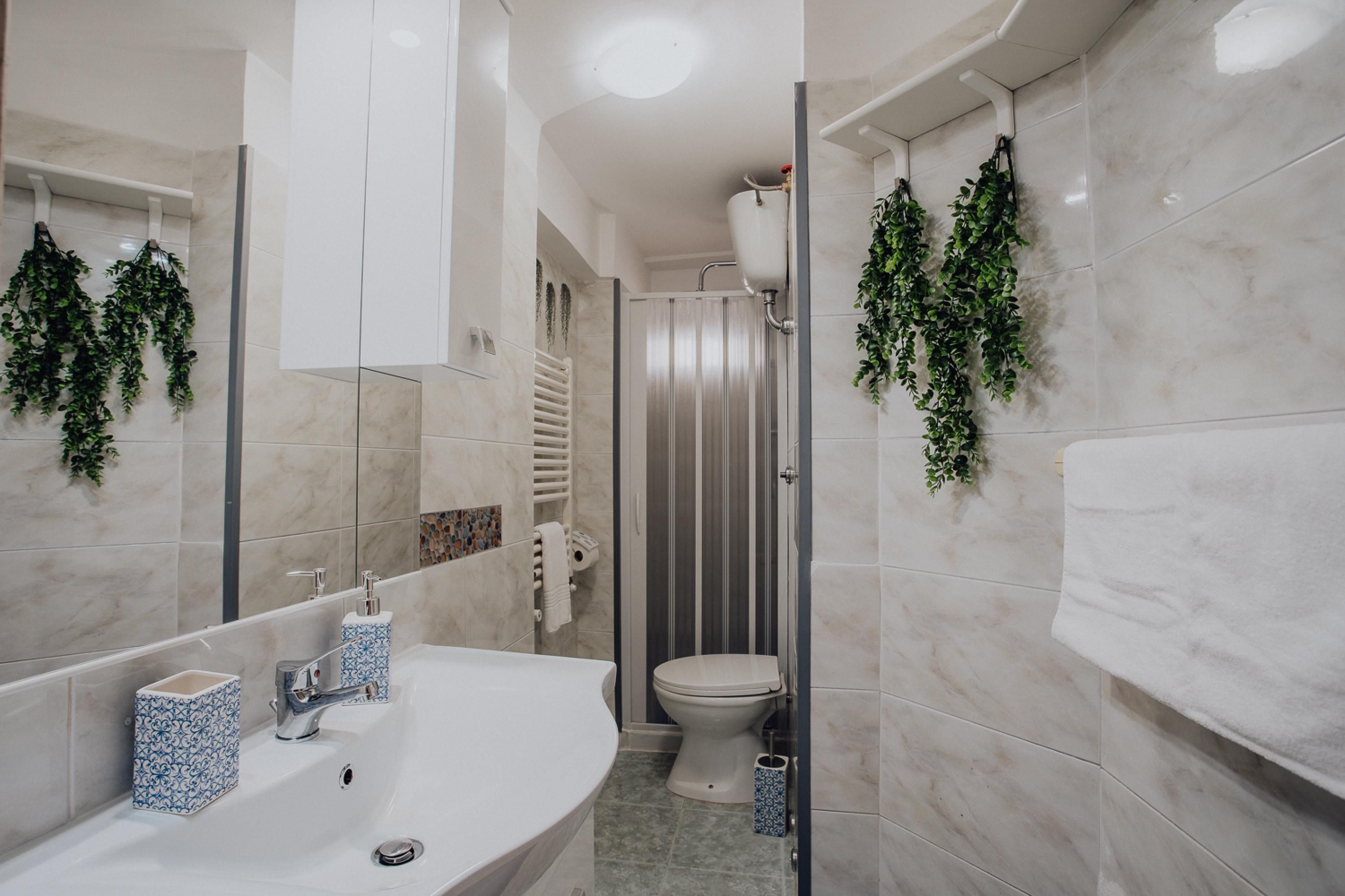 Een moderne badkamer met een wit wastafelmeubel, toilet en douche.