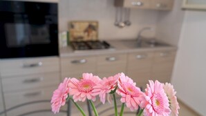 A modern kitchen with a stove, sink, and cabinets. - Appartamento 69 in Casalabate (Squinzano)