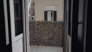 A view through a glass door with a metal gate, leading to a balcony with a patterned metal fence. - Dimora Silvia in Monopoli (Monopoli)