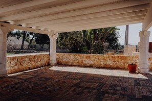 An outdoor covered patio area with stone walls and a brick floor. - Villa Carla al Capitolo (Monopoli)