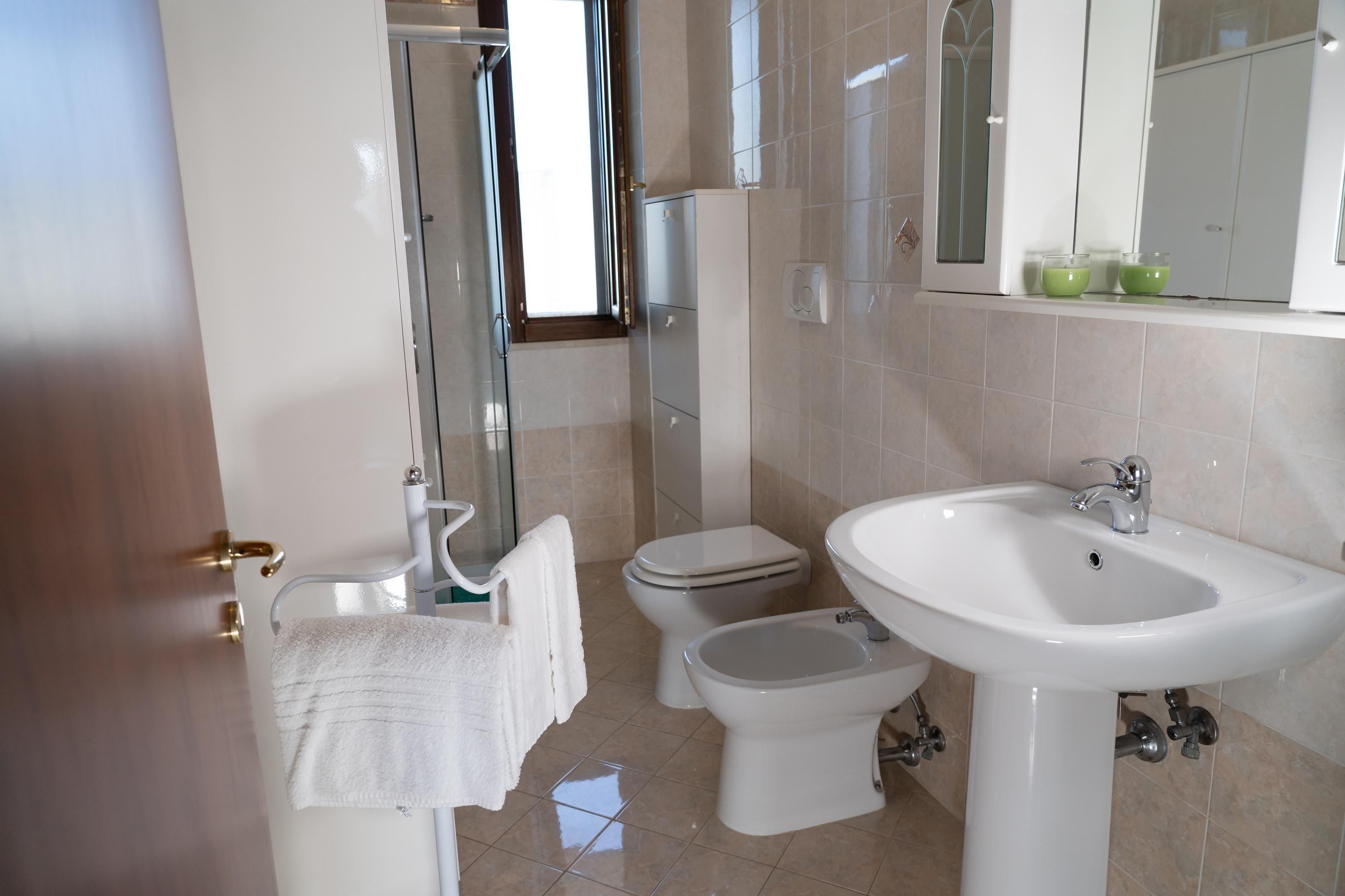 A bathroom with a toilet, bidet, and sink.