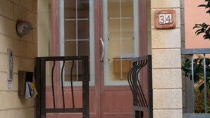 A building entrance with a number 34 sign, a metal gate, and a wall-mounted security camera. - Elle Dimore in Lecce (Lecce)
