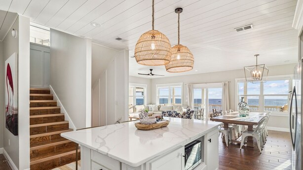 A spacious kitchen with a large island, white cabinetry, and a view of the ocean. - Pet-Friendly Beach House w/ Heated Pool (Port St. Joe)