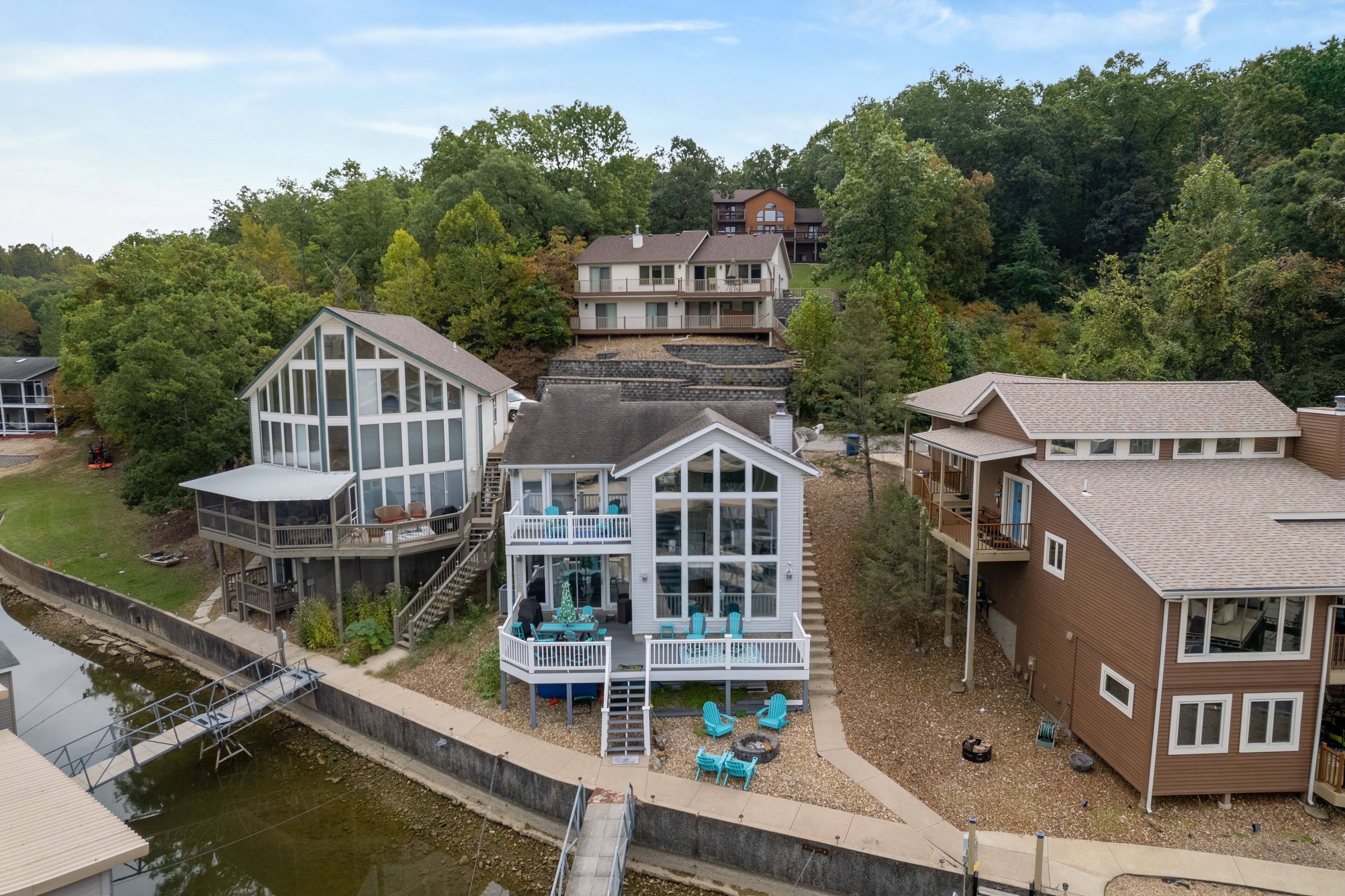 A multi-story house with a balcony, a dock, and a small boat.