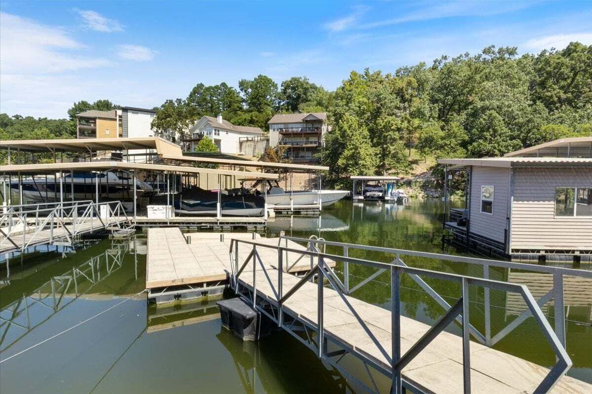 Un port de plaisance avec des bateaux amarrés, une jetée en bois et une petite construction qui ressemble à une maison, située sur la droite.