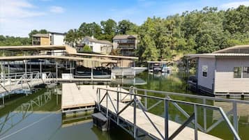 Un port de plaisance avec des bateaux amarrés, une jetée en bois et une petite construction qui ressemble à une maison, située sur la droite.