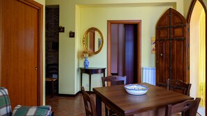 A dining area with a wooden table, chairs, a vase, and a mirror. - Il Ciliegio ,'le Calme et la Tranquillité Sont Notre Carte de Visite' (Castelbuono)