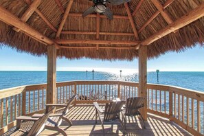 A wooden deck with a thatched roof, overlooking the sea. - Toes in the Sand - 2 Bedroom Condo Sleeps 4 (Tavernier)