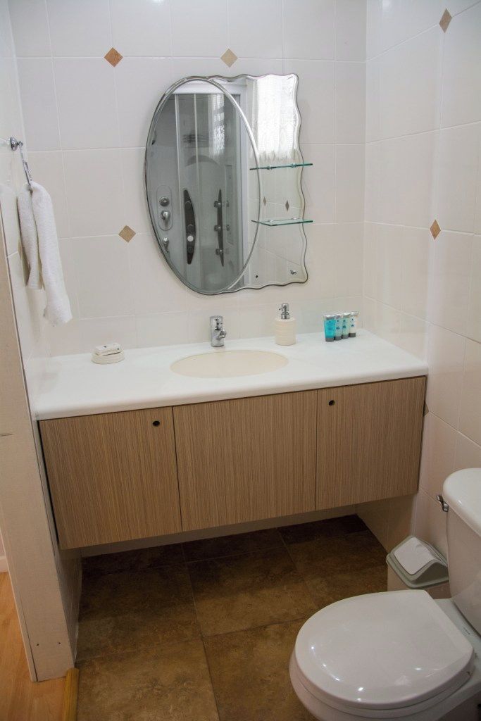 Un bagno con un lavandino bianco, uno specchio e un water.