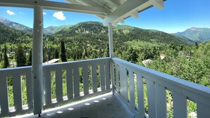 A balcony with a view of a forested mountain range. - Whispering Pines by Cottonwood Lodging (Brighton)