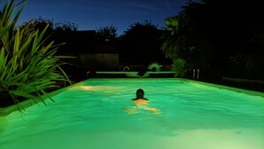 A swimming pool with a person in the water, surrounded by greenery. - Hyper-Gite: very large barn converted into gites (Corpe)