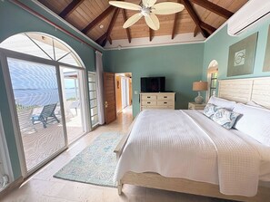 A bedroom with a bed, a television, a nightstand, and a window.
