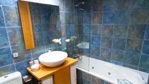 A modern bathroom with a white toilet, a wooden vanity with a large sink, a glass-enclosed shower, and a bathtub. - Apartamento Idaira Paradise (Playa Paraíso)