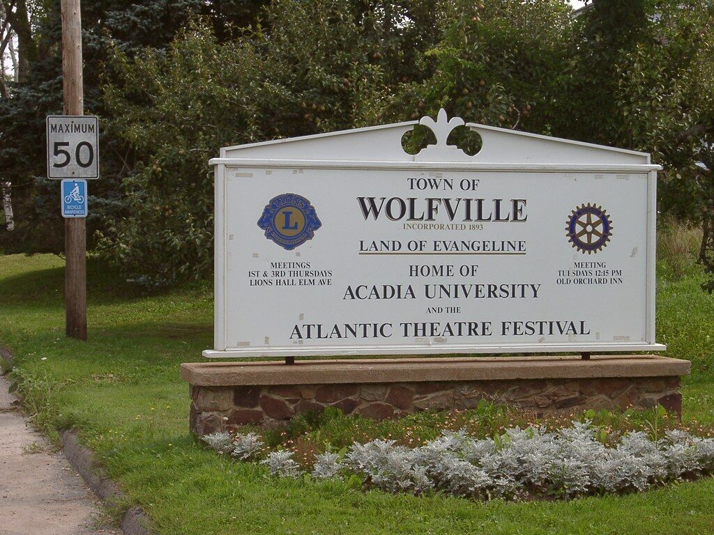Un panneau indiquant l’entrée de la ville de Wolfville, mentionnant l’année de sa création, les jours où se tiennent les réunions du conseil municipal, ainsi que les principaux monuments et lieux d’intérêt, comme l’université Acadia et le festival de théâtre Atlantic.