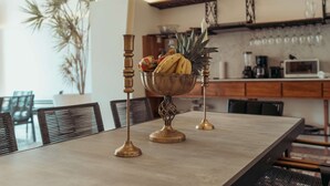 Una mesa de comedor con un frutero y candelabros.
