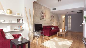 Una sala de estar moderna con un sofá rojo, un televisor, una estantería y una chimenea.
