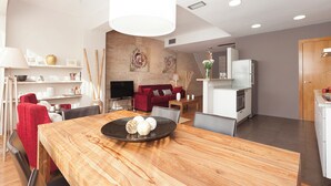 A modern living room with a dining area, featuring a wooden table, red sofa, and a kitchen in the background. - Sant Pau 5 - Superb 3-bedroom apartment in central Barcelona (Barcelona)