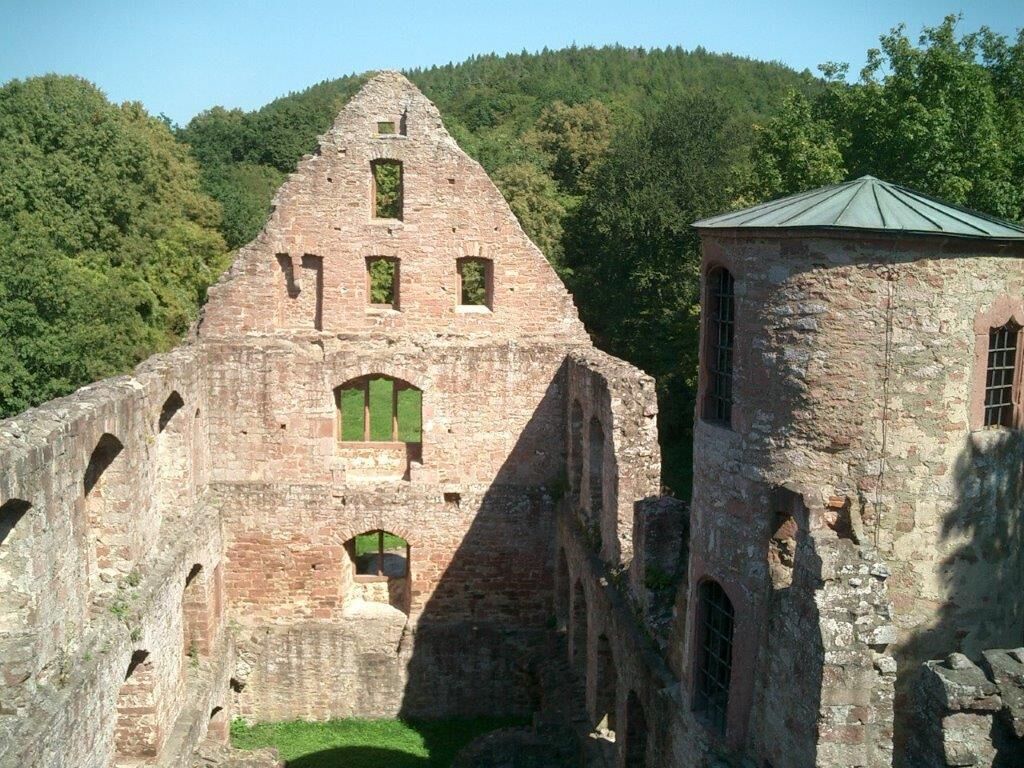 An ancient stone structure with arched windows and a small tower.