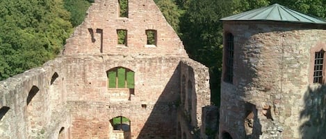 An ancient stone structure with arched windows and a small tower.
