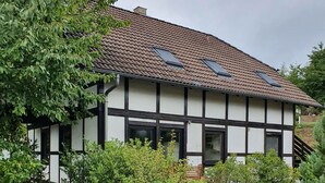 Et traditionelt bindingsværkshus med tegltag og solpaneler.