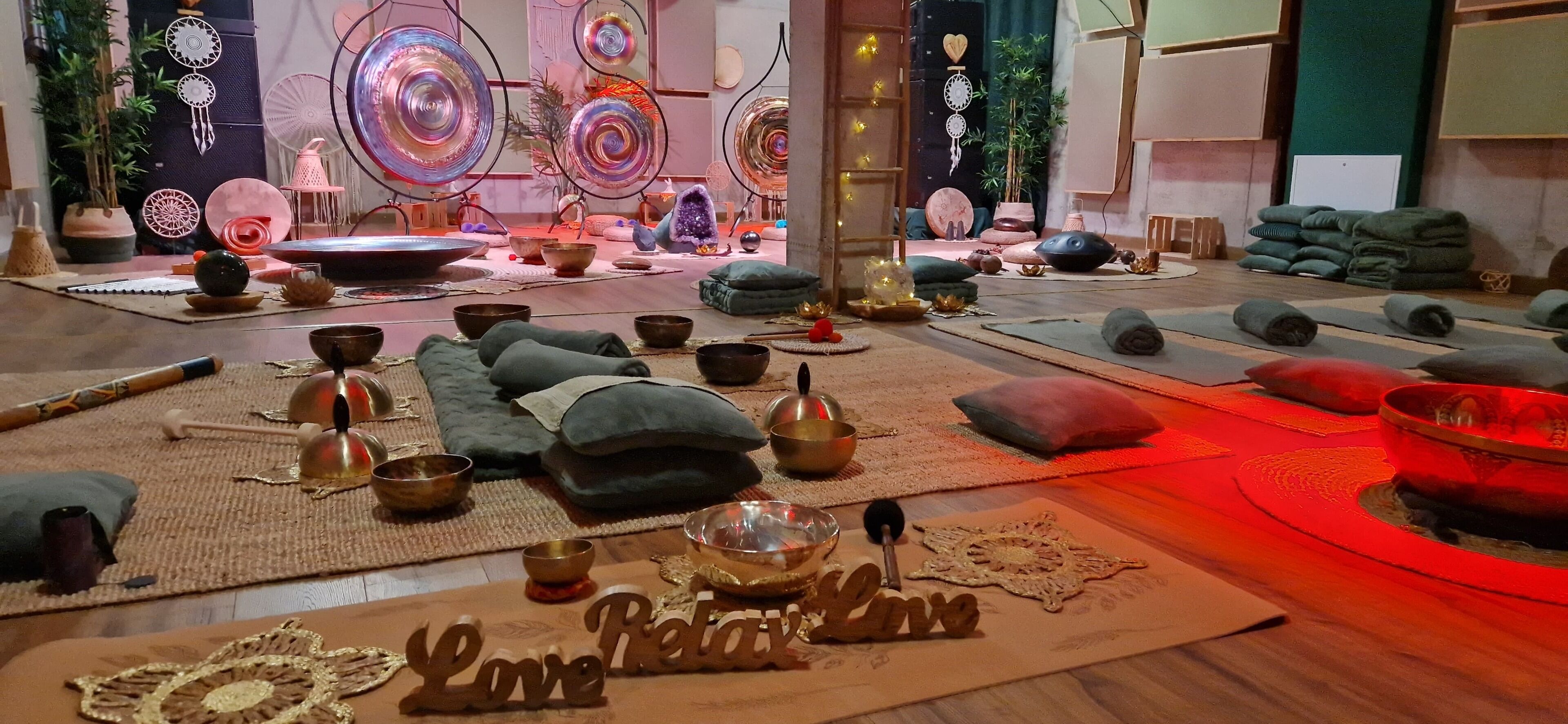 Ein Zimmer mit Yogamatte, Meditationskissen und einem Holzschild mit der Aufschrift 'Love Retreat'.