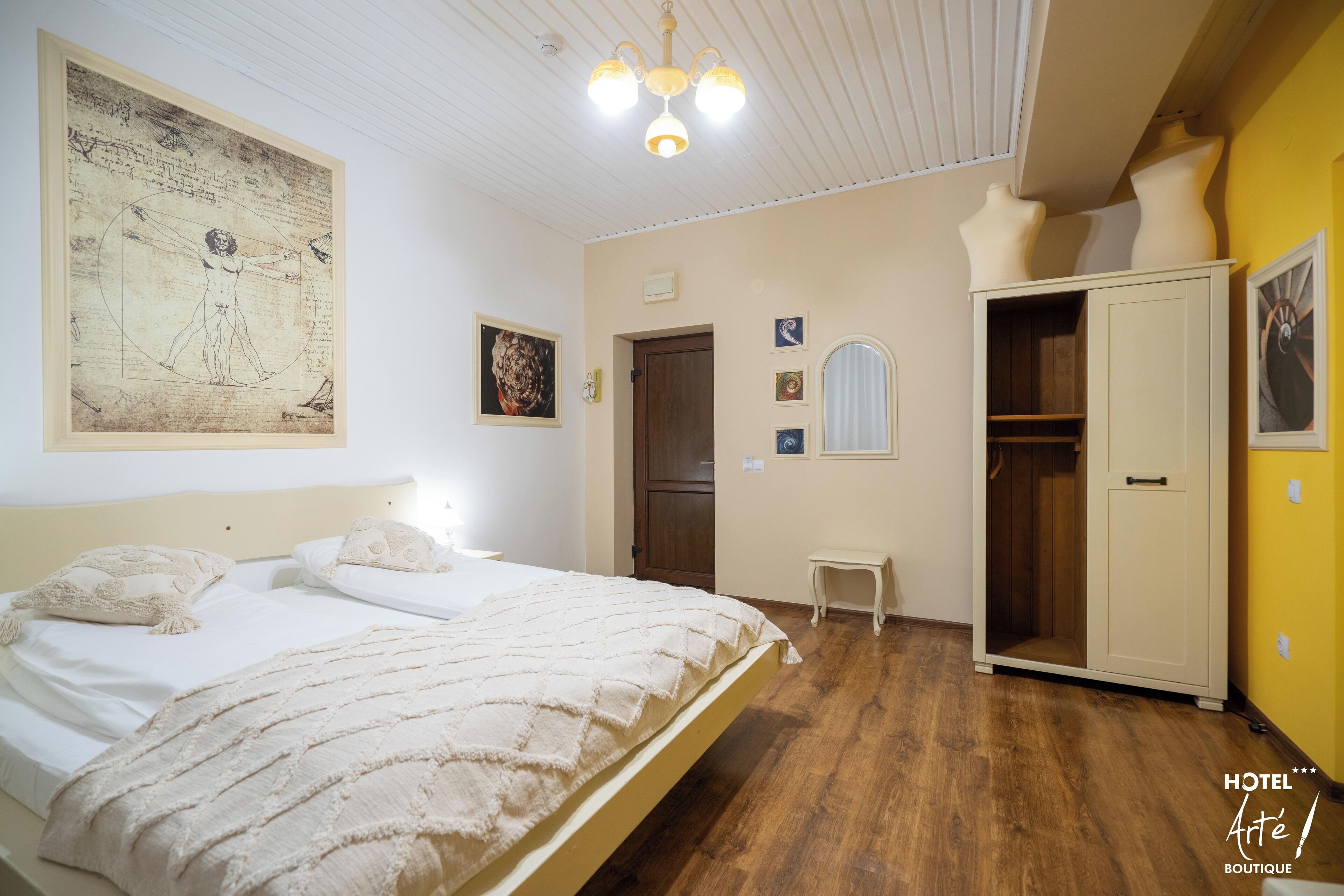 A bedroom with a large bed, a wardrobe, and a ceiling light fixture.