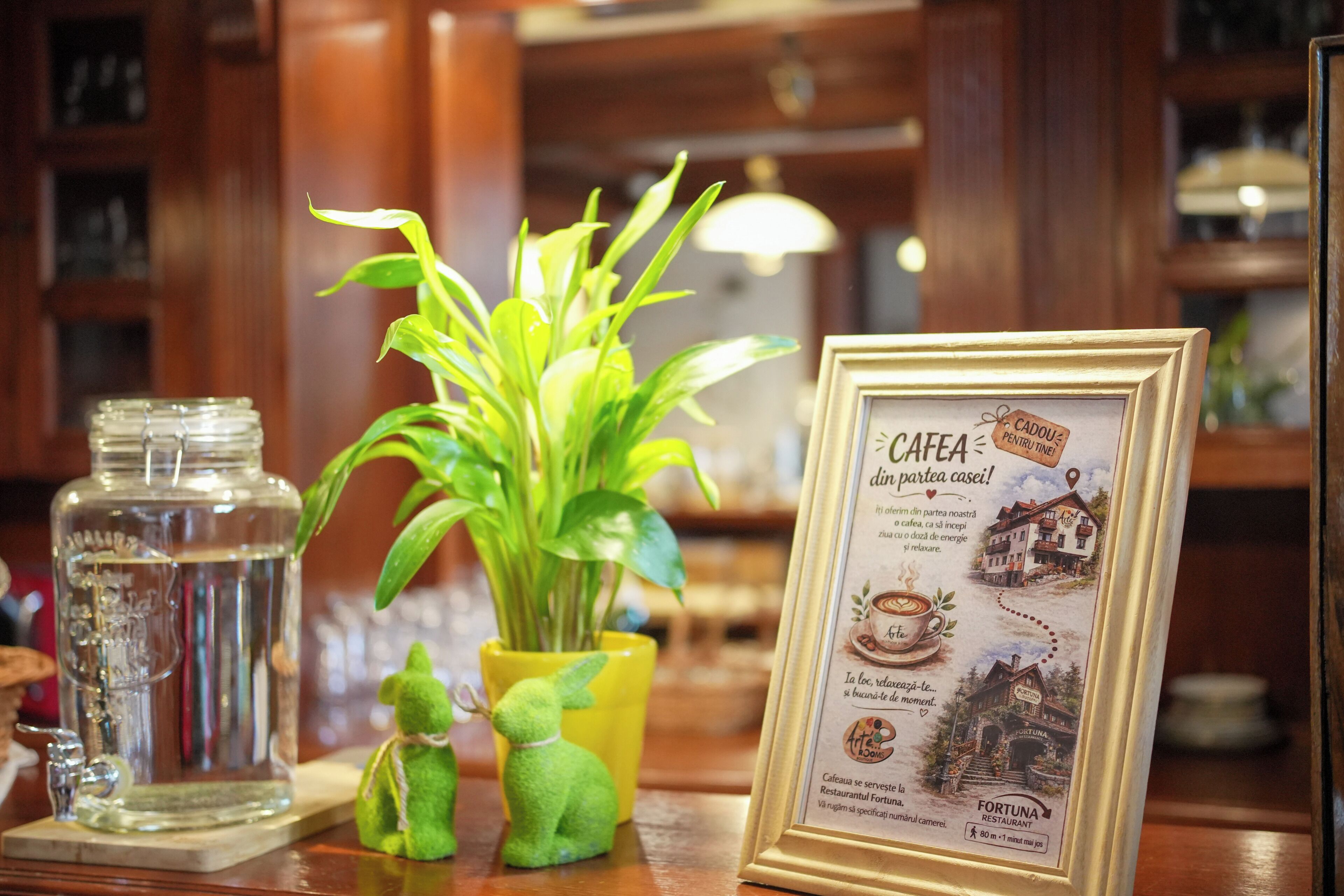 Un menú enmarco con texto e imágenes de una cafetería, un frasco de vidrio y una planta en maceta sobre una mesa de madera.