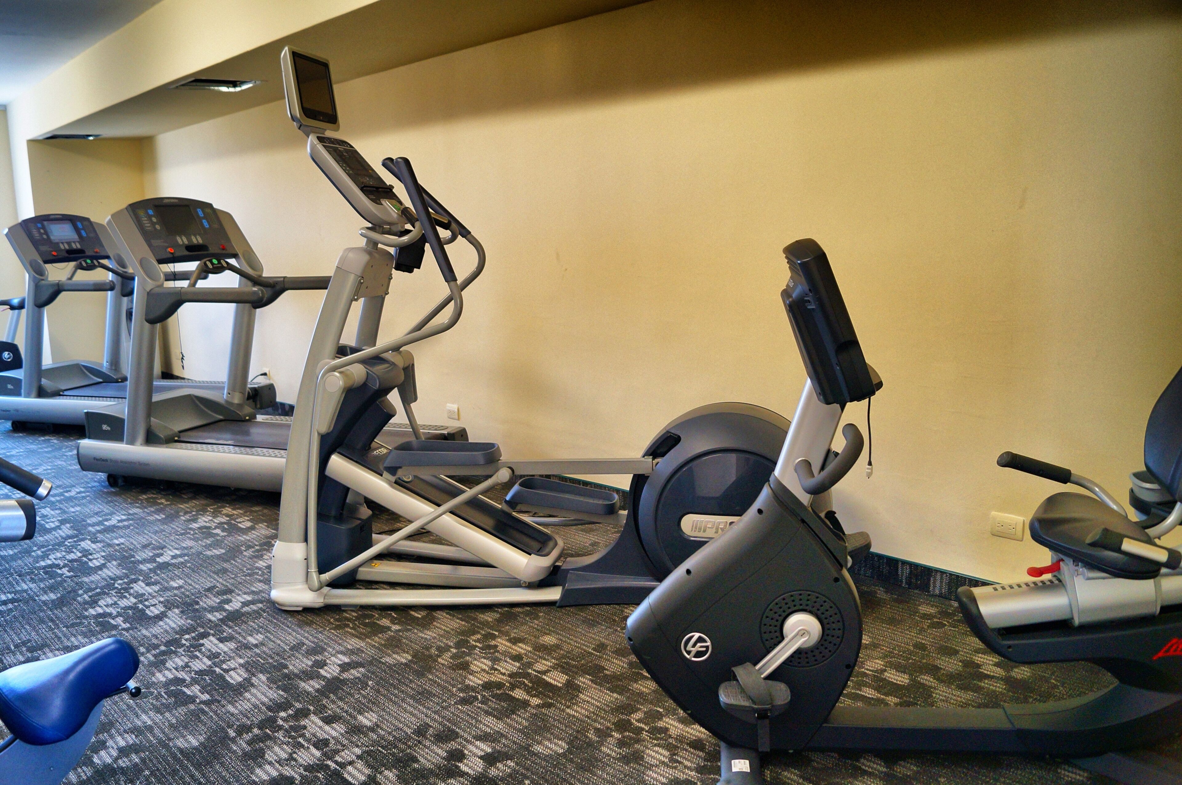 A gym with treadmills, an elliptical, and a stationary bike.