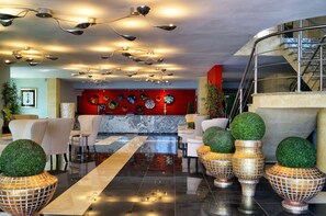 A lobby with a marble reception desk, multiple seating areas, and a staircase. - Los Cedros Hotel Inn Torreon (Torreón)