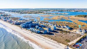 An aerial view of a coastal resort with beachfront properties, a marina, and a golf course. - Luxurious 7BR Beach Home w/ Ocean Views, Pool, Hot tub, and Elevator (North Topsail Beach)