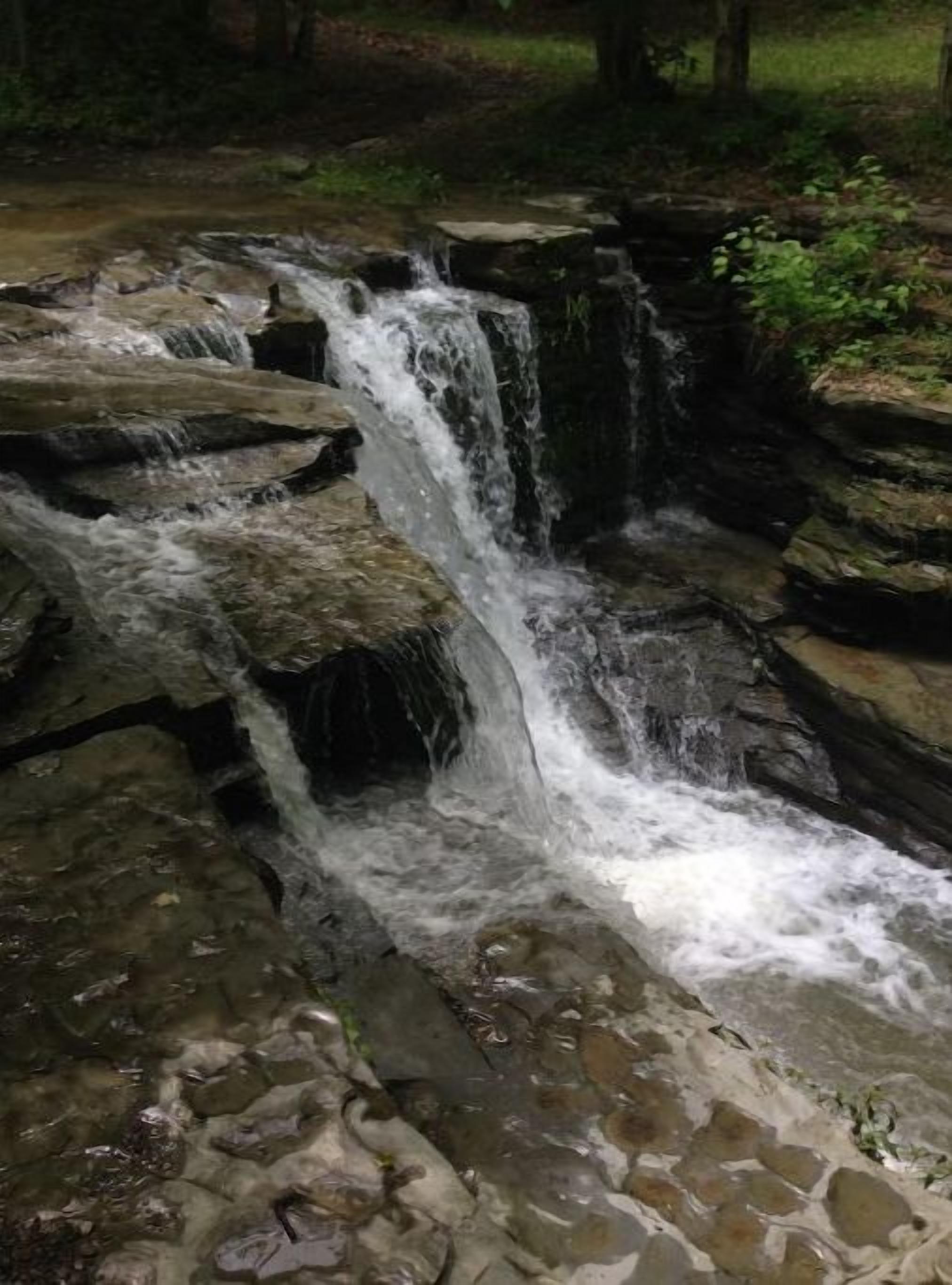 A waterfall cascading over rocks in a natural setting.