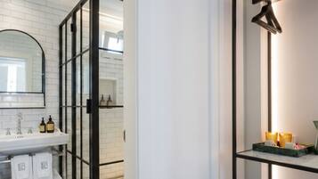 Een moderne badkamer met een wit wastafelmeubel, spiegel en een douchecabine met een zwarte omlijsting.