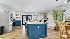 A modern kitchen with a central island, wooden flooring, and built-in appliances. - Lake and marina 5 minutes away Large family friendly Cozy home with country feel (Leesburg)