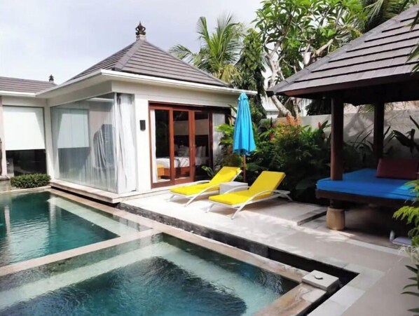 Relax by the serene pool surrounded by lush greenery and modern architecture.