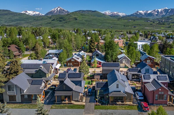 A residential area with houses featuring sloped roofs and a backdrop of snow-capped mountains. - Fairy Slipper at Academy Place (Crested Butte)