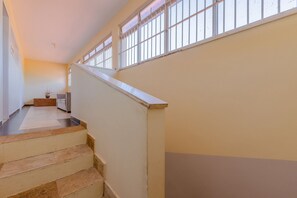 A staircase with beige steps leading to a landing with a white railing. - Casa melhor de Porto das D - Carpediem (Aquiraz)