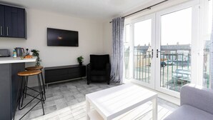 Une cuisine moderne avec un coin bar, une table à manger et une chaise noire.