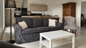 A modern living room with a grey sofa, a white coffee table, and a lamp.