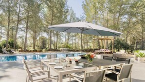 An outdoor dining area with a pool, surrounded by trees. - Charming Villa in the Nature of Santa Gertrudis (Islas Baleares)