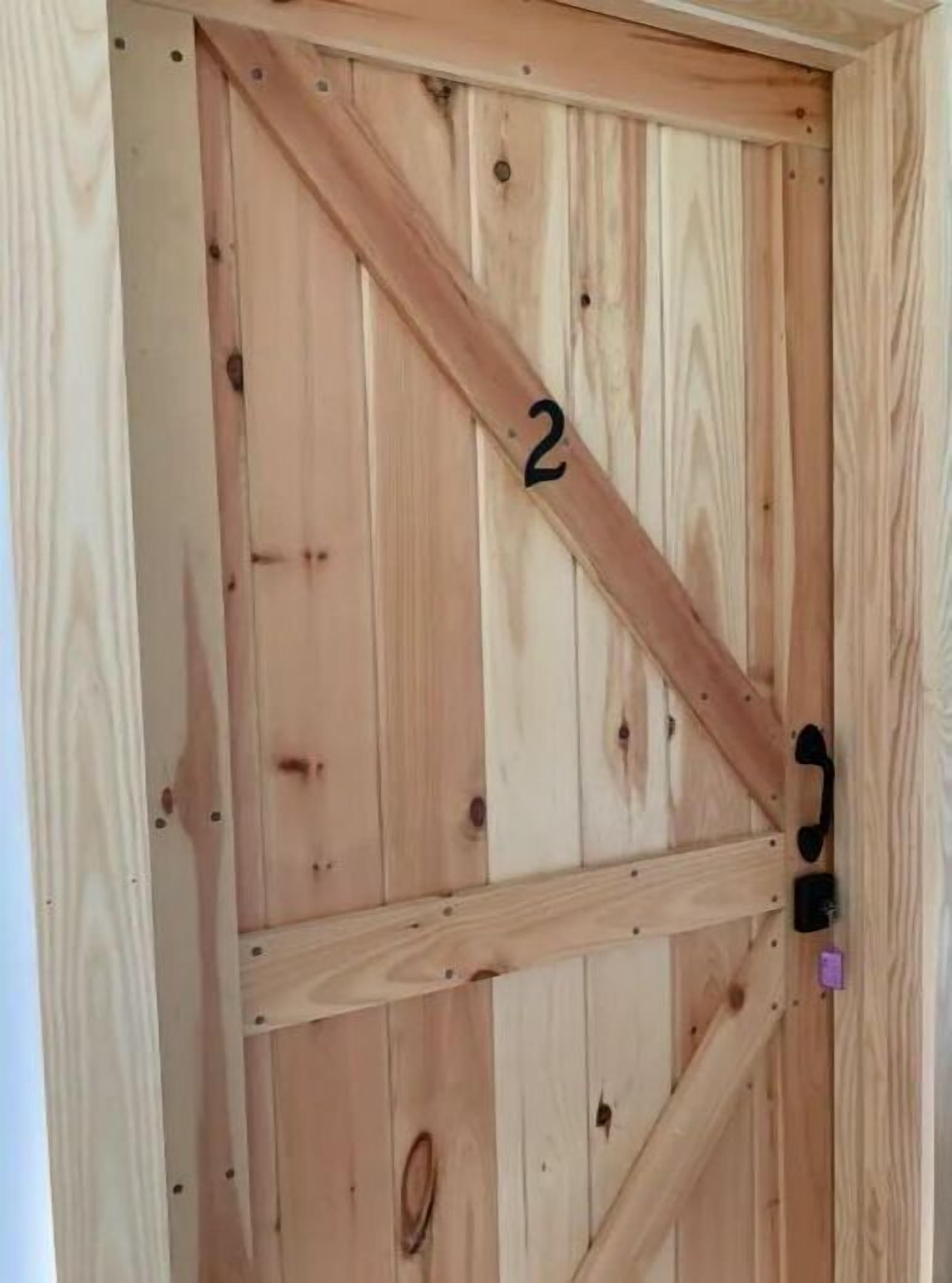 A wooden door with a number '2' and a black handle.