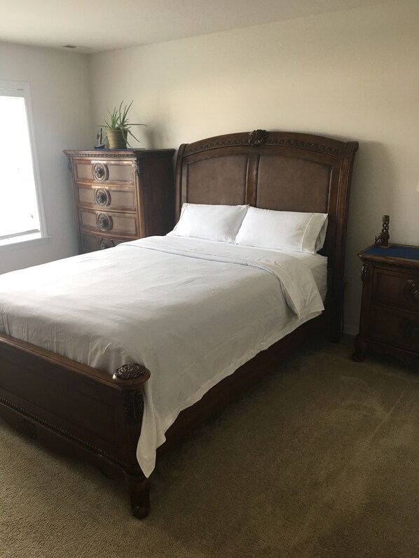 A bedroom with a wooden bed, a dresser, and a nightstand. - Welcome to the Lighthouse! Charming 3-bdrm home with 2 decks in Virginia Beach (Virginia Beach)