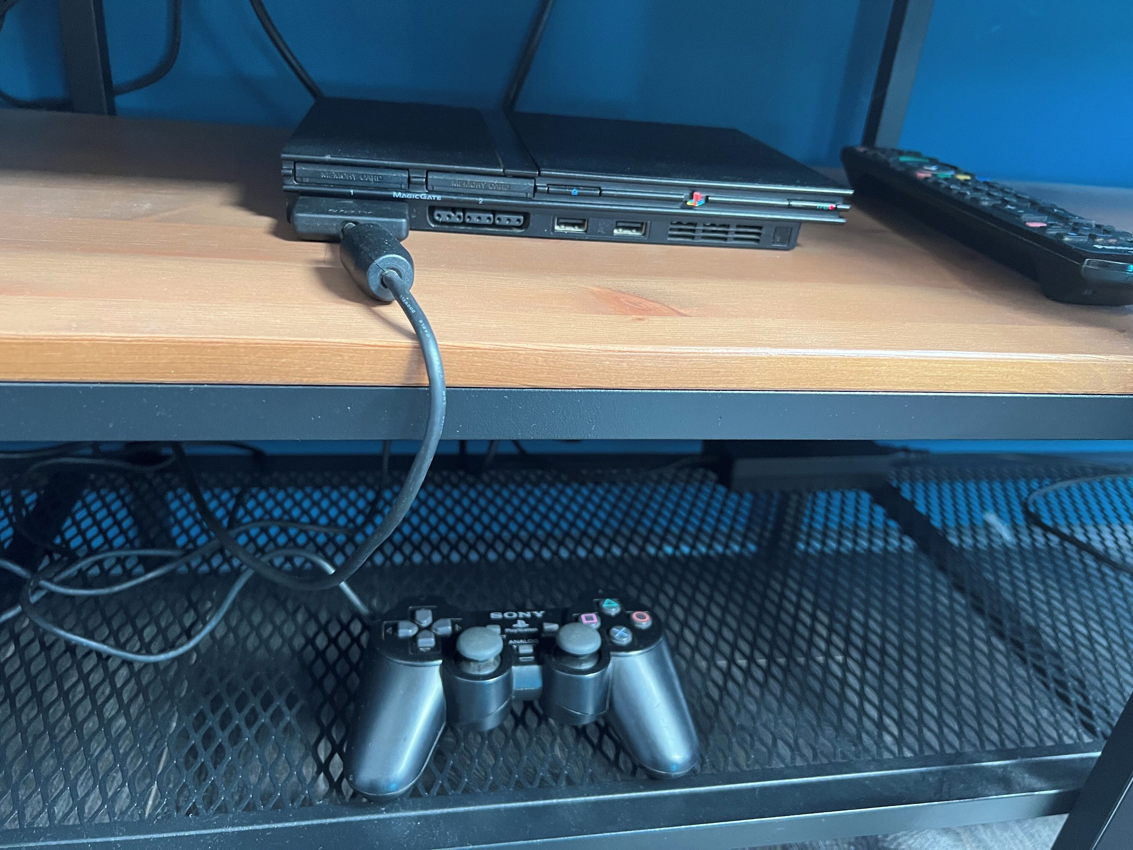 Ein Laptop auf einem Holztisch mit Tastatur, Maus und zwei Spielecontrollern.