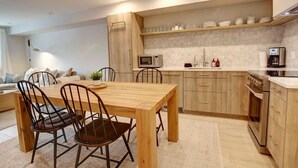 Una cocina moderna con armarios de madera, microondas integrado y cafetera.