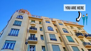 A multi-story building with balconies and large windows.
