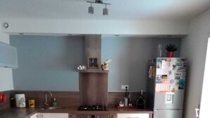 Una cocina moderna con una mesa de comedor, sillas, estufa, lavamanos y refrigerador.