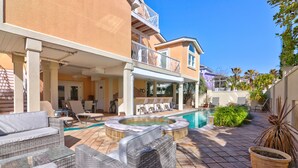 Zona de piscina con mobiliario de mimbre y un jacuzzi.
